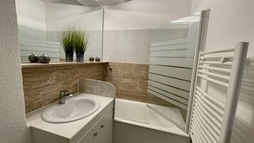 Een bad/douchecombinatie, een haardroger