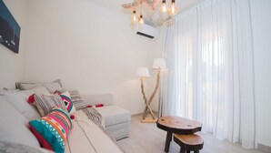 A modern living room with a sofa, a small table, and a lamp. - T' adelfia  -  ERMIS (Corfu)