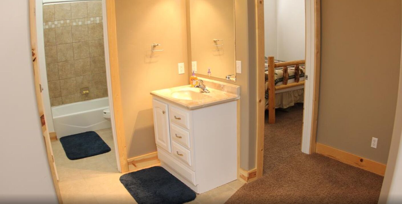 Un bany amb un lavabo, un mirall i una dutxera.