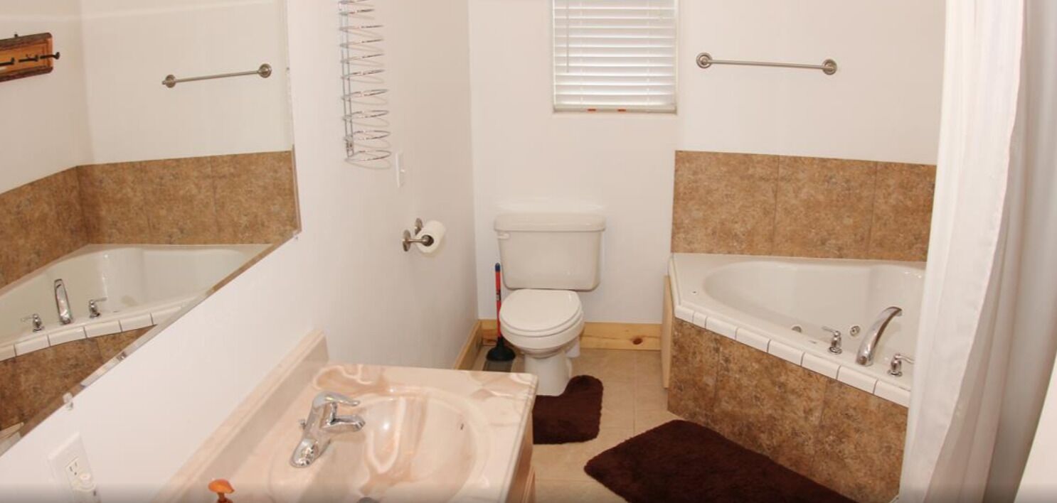 Un baño con bañera, lavabo, inodoro y zona de ducha.