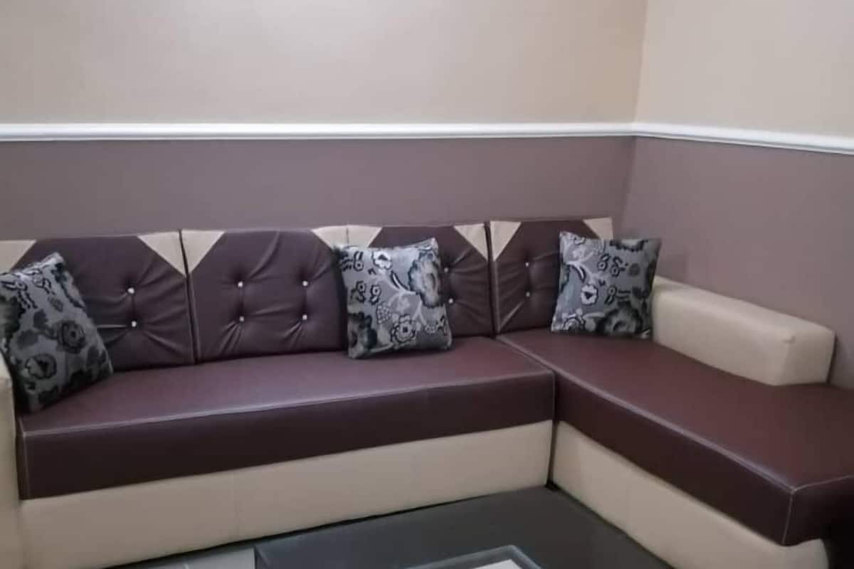 A modern living room with a sectional sofa, a black coffee table, and patterned throw pillows.