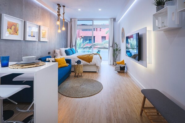 Ein modernes Wohnzimmer mit einer Couch, einem Couchtisch und einem an der Wand befestigten Fernseher.
