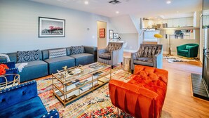 A modern living room with a sofa, armchairs, and a coffee table.