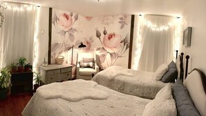 Een slaapkamer met twee bedden, een nachtkastje, een stoel en een dressoir.