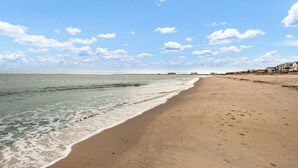 Een strand met heldere lucht en een kalme zee.