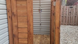Eine Holzpergola mit einer Tür, die zu einem überdachten Außenbereich führt.