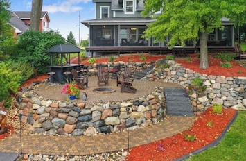 Lakefront area with Adirondack chairs, dining table, tiki bar and fire pit!