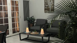 Un salon moderne avec un canapé, des fauteuils, une table basse et une plante en pot.