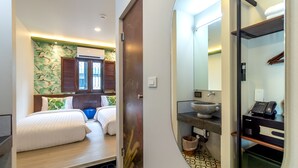 Ein Hotelzimmer mit Bett, kleinem Badezimmer und Spiegel.