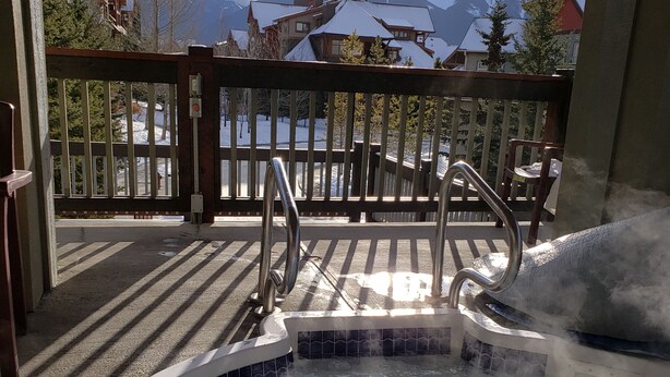 A hot tub with a view of snow-covered mountains. - Spacious 3 BR Top Floor Condo - Kitchen, Mountain View Balcony, Fireplace & Pool (Canmore)
