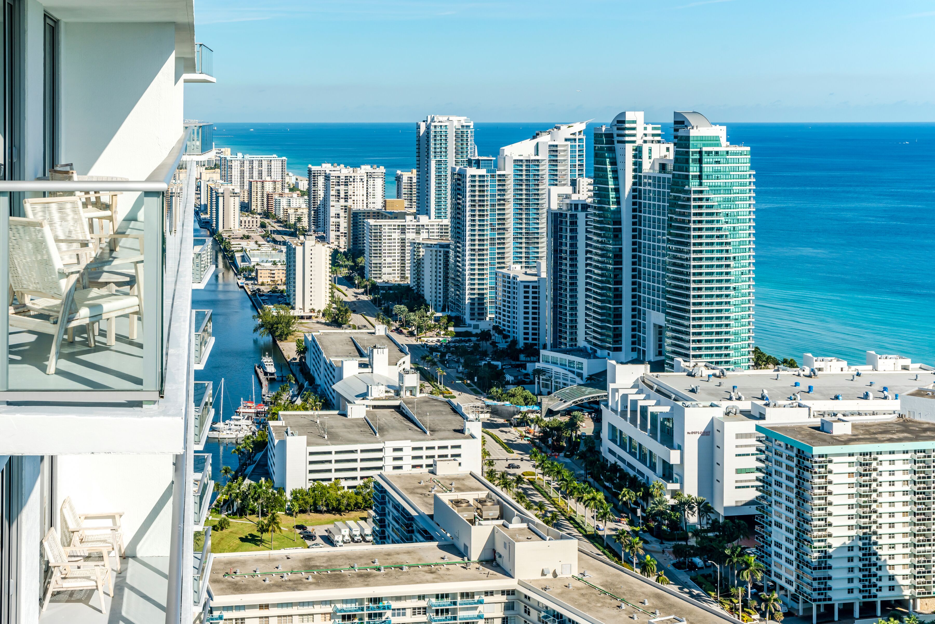 A high-rise building with a view of the ocean and other buildings.