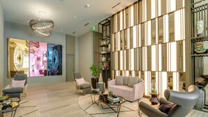A modern living room with a sofa, armchairs, a coffee table, and a decorative wall with artwork.