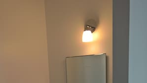 A small bathroom with a white sink, a mirror, and a light fixture above the mirror. - T4 center LOURDES and near sanctuaries (Lourdes)