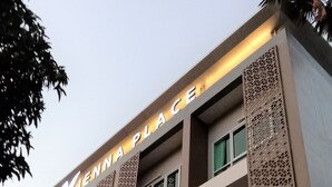 Un hotel de varios pisos con balcones y paneles de celosía decorativos.