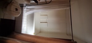 Simple, elegant space with a wooden bench and a partially drawn curtain.