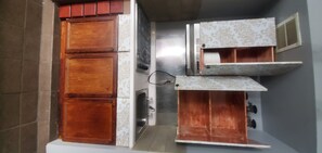 Compact kitchen with appliances and cabinetry, featuring a traditional design and sink.