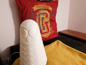 A white object resembling an owl, a red pillow with a large letter 'G', and a yellow cloth. - Cozy Central II Comfortable, welcoming Studio (Ponta Delgada)