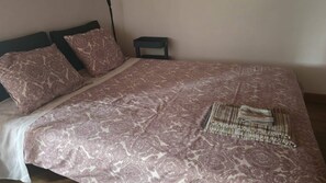 A bed with a patterned bedspread, two pillows, and a folded blanket. - Cozy Central II Comfortable, welcoming Studio (Ponta Delgada)
