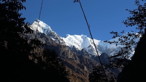 A mountain range with snow-capped peaks, surrounded by rocky terrain and sparse vegetation. - Shree yoga retreat (Kathmandu)