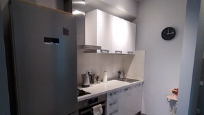 Een moderne keuken met een ingebouwde koelkast, oven en spoelbak.