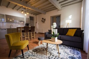 A modern living room with a sofa, a yellow chair, a coffee table, and a patterned rug.