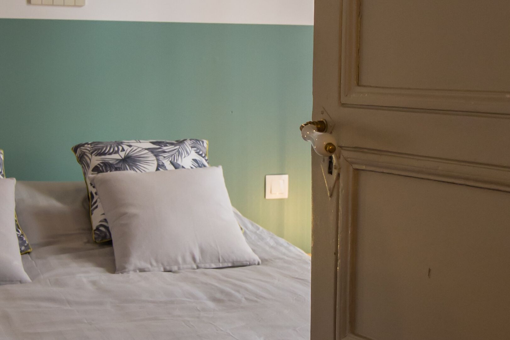 Une chambre à coucher avec un lit, des oreillers et une porte.
