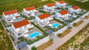 A modern residential complex with multiple two-story houses, each featuring a swimming pool and outdoor seating areas. - Amazing home in Debeljak (Debeljak)