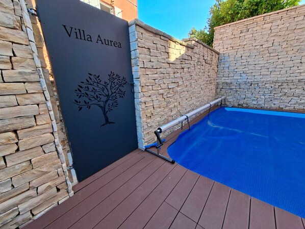 A pool area with a stone wall and a sign reading "Villa Aurea". - Villa Aurea, beach vacation home, two double rooms, heated pool, sauna (Čižići)