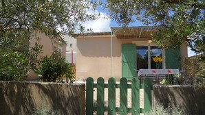 A house with a green gate, a table with a white tablecloth, and a window with green shutters. - A Mazet at the foot of the Alpilles (2 stars) (Saint-Rémy-de-Provence)