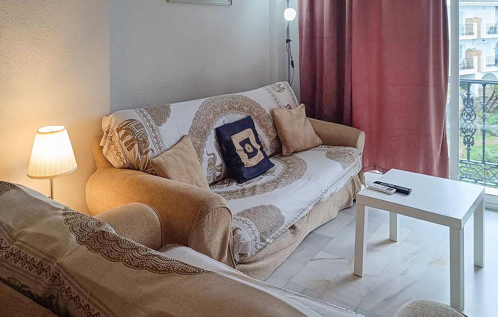 Una sala de estar acogedora con un sofá, una mesita y una lámpara.