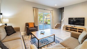 A modern living room with a sofa, a coffee table, and a TV.