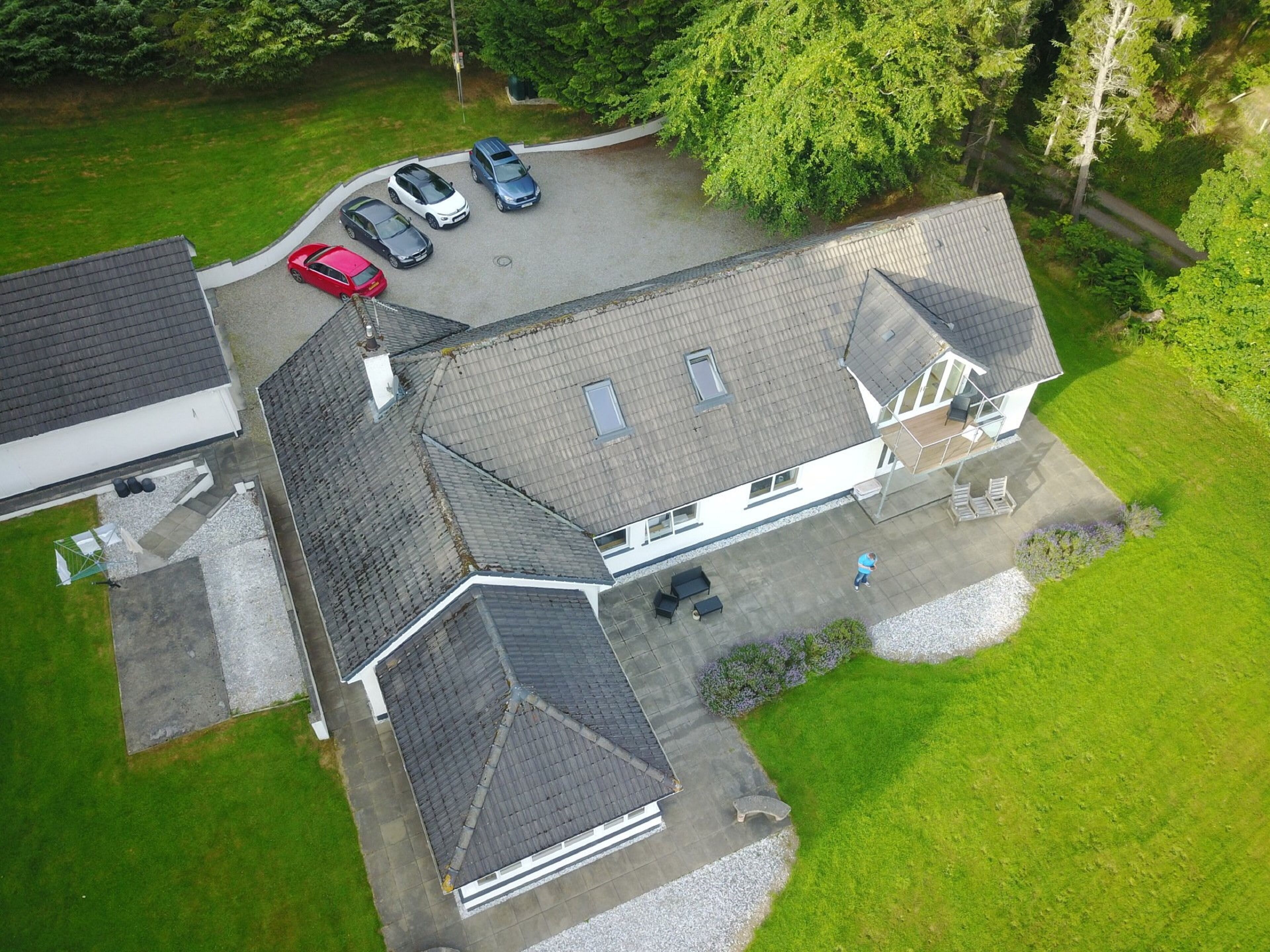 An aerial view of a house with a garage, a driveway, and a lawn.
