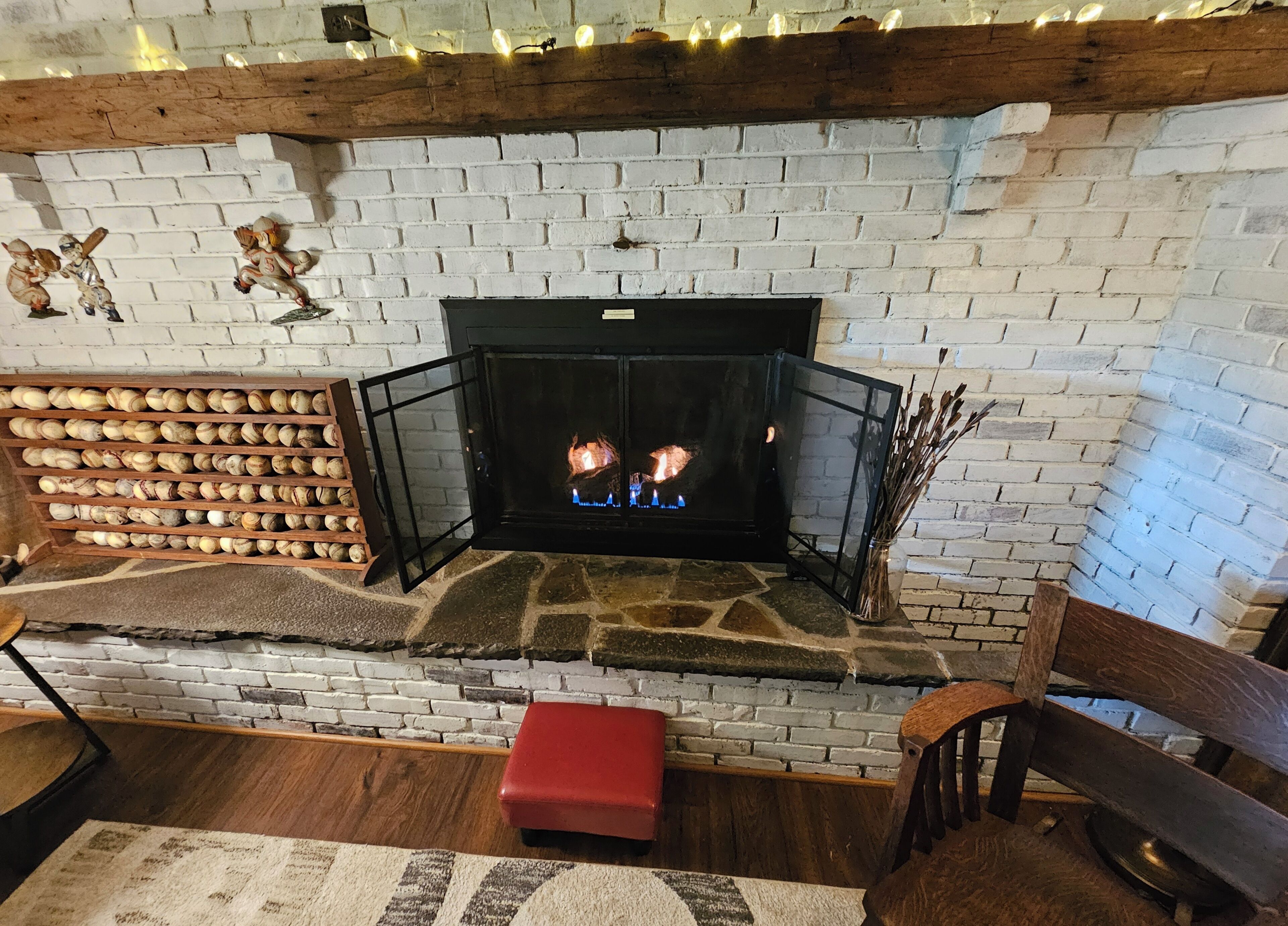 A fireplace with a stone surround, a bench, and a shelf with nuts.