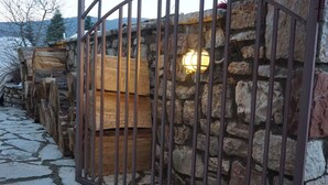 A stone wall with a metal gate and a wooden bench.