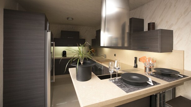 A modern kitchen with a central island, stainless steel appliances, and a large range hood. - AlmerimarDuplexlujoo/sea view/JACUZ private / 🆓WIFI/SMART tv / lav-sec🐎⛳️🏄‍♂️ (Almerimar)