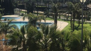 A resort with multiple swimming pools, palm trees, and a clear view of the surrounding area. - AlmerimarDuplexlujoo/sea view/JACUZ private / 🆓WIFI/SMART tv / lav-sec🐎⛳️🏄‍♂️ (Almerimar)