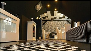 Un hall d’hôtel moderne avec un tapis à motifs, un comptoir d’accueil et un mur décoratif.