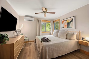 A bedroom with a bed, bedside table, nightstand, ceiling fan, window, and a TV. - SnowPine Condo, Sleeps 8, A/C, Fireplace (Ellicottville)