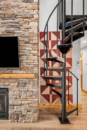 Eine Wendeltreppe mit einer Steinwand und einer Wand dahinter mit geometrischem Muster.