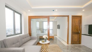 Una sala de estar moderna con un sofá gris, una mesa de centro con un florero y una alfombra estampada.