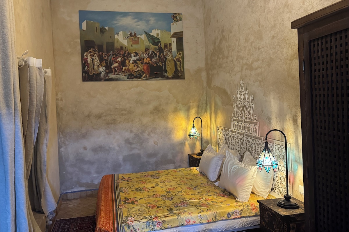 Une chambre à coucher avec un lit, un tableau au mur, une table de chevet et un élément décoratif mural.