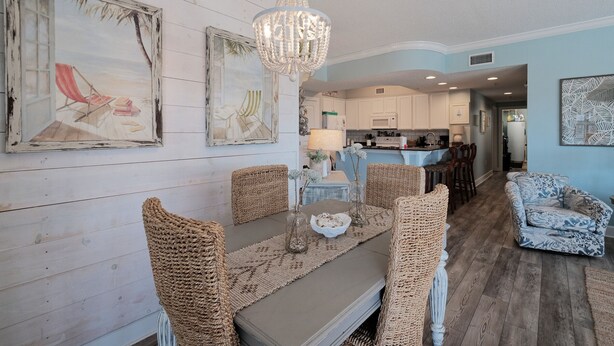 Un coin repas avec des chaises en osier, une table avec un set de table et un lustre.
