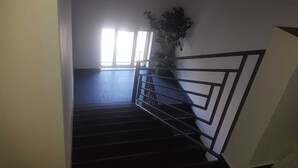 Eine Treppe mit Metallgeländer, die zu einer Zwischenebene führt.