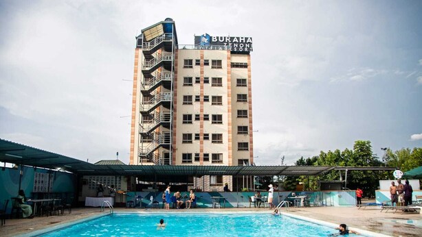 A swimming pool area with a building labeled "BURAHA ZENON RESORT" in the background.