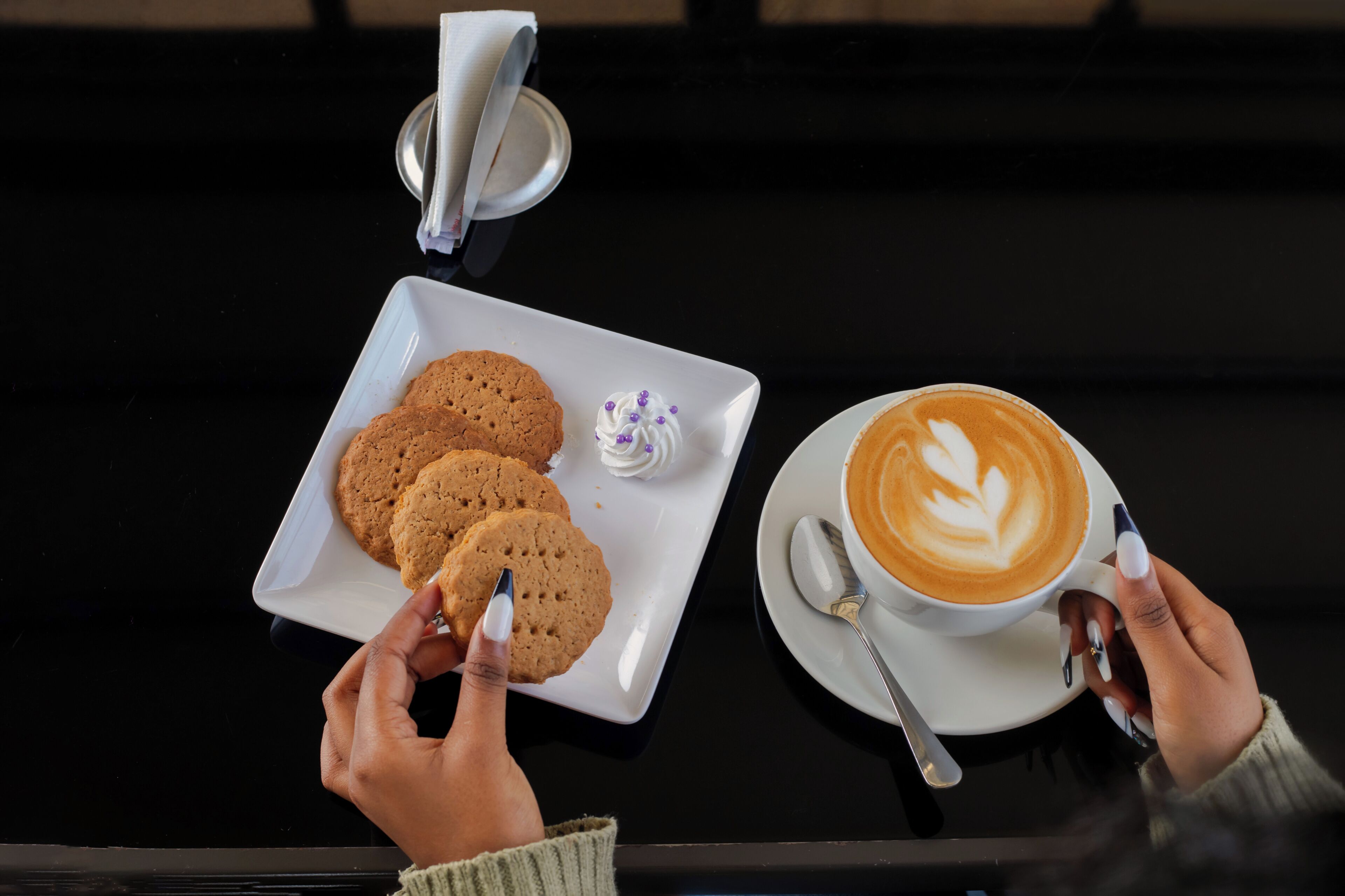 Une table avec une assiette de biscuits et une tasse de café.