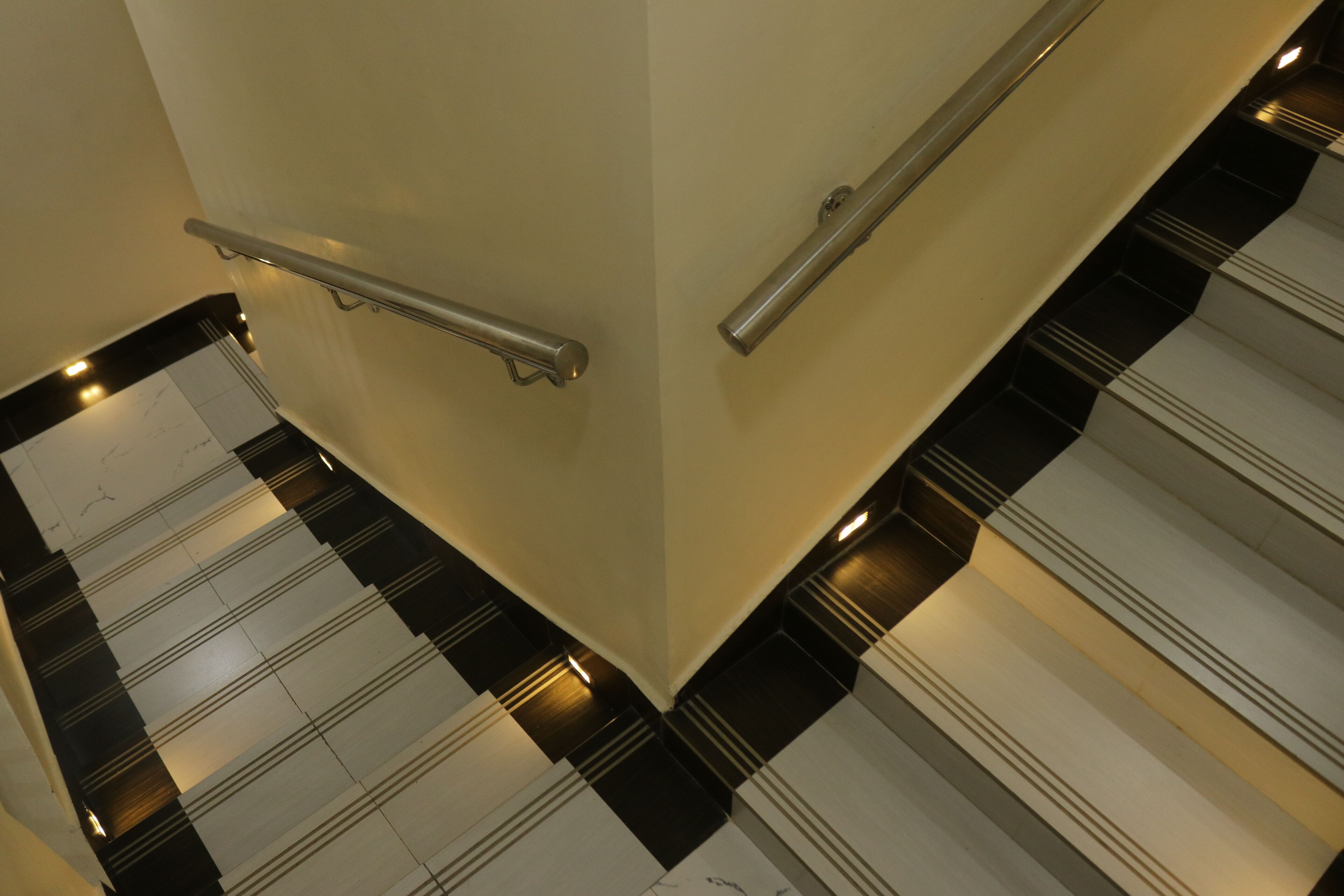 A staircase with black and white patterned steps and metal handrails.
