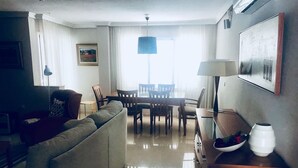 A modern living room with a sofa, dining table, chairs, a lamp, and a vase on a side table. - Private pool beach. Sohail Castle (Fuengirola)