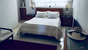 A neatly arranged hotel room with a bed, bedside tables, a chair, a desk, and a window with curtains. - Private pool beach. Sohail Castle (Fuengirola)