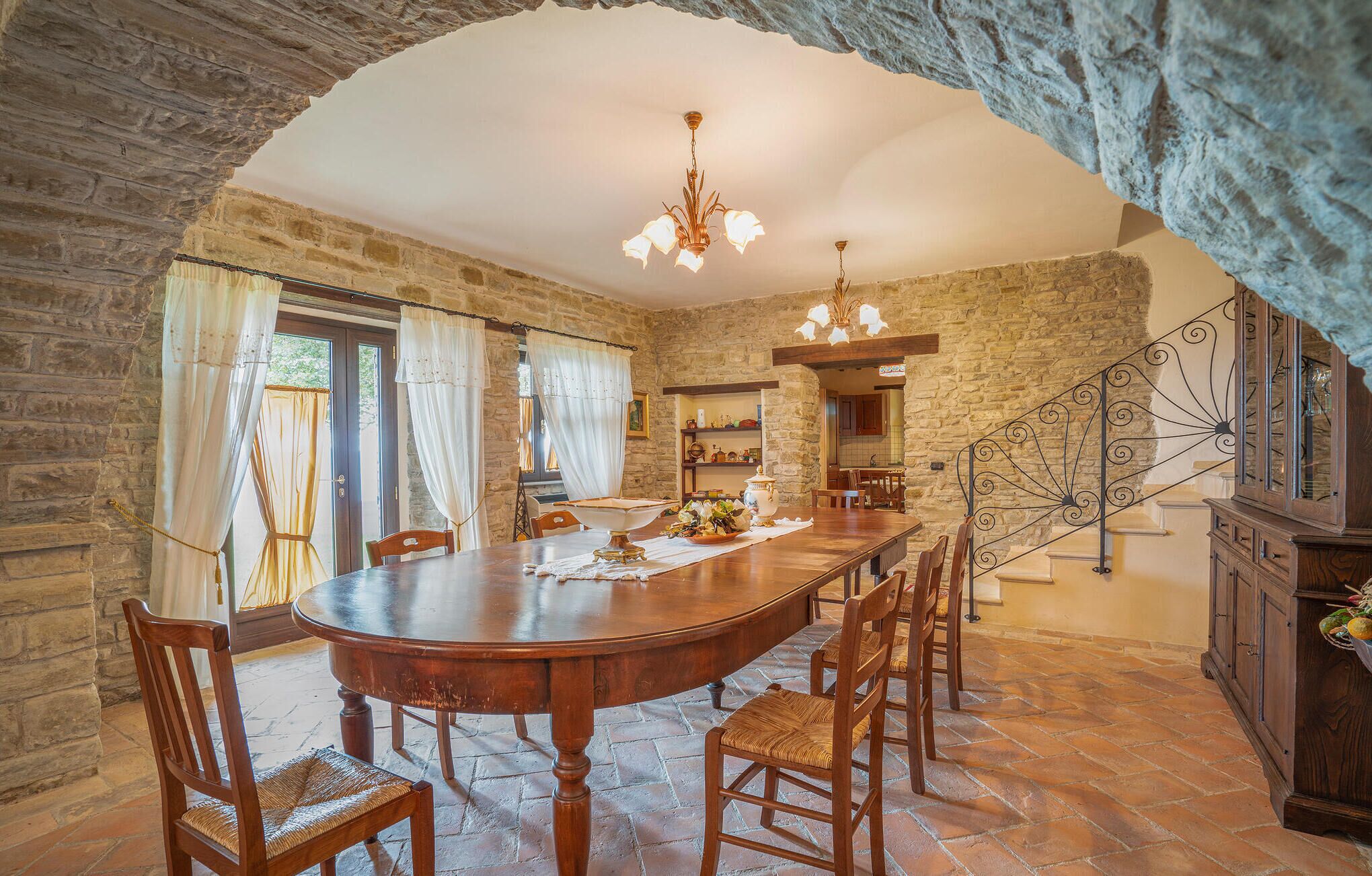 A dining area with a stone wall, a wooden table, and chairs.