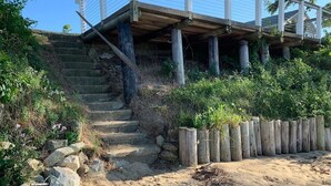 Eine Holztreppe führt zu einem Gebäude mit einem Balkon.